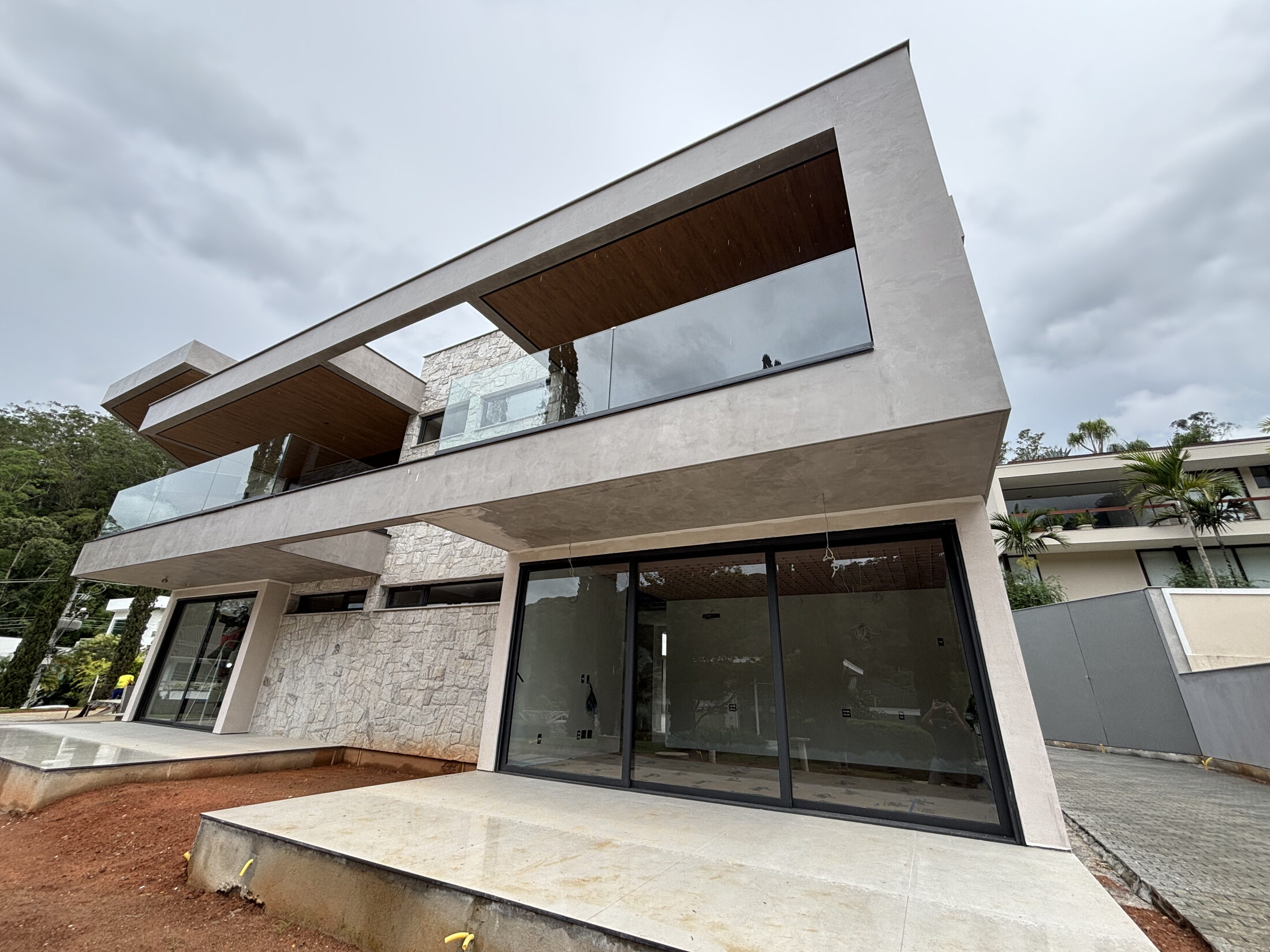 Fachada contemporânea de residência de alto padrão, estrutura em balanço e revestimento em pedra